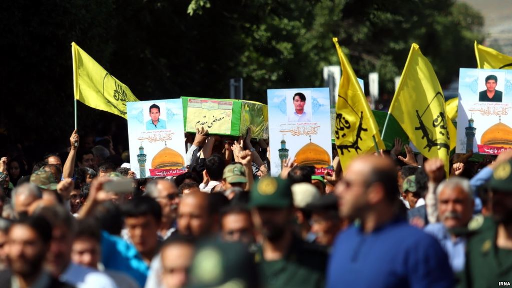 Funeral for Afghan Fatemiyoun Brigade fighters killed in Syria. Posters feature Sayyeda Zainab shrine. (Source: Islamic Republic News Agency)